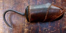 an old leather cup with a handle on a wooden table