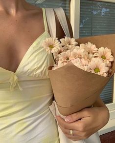 a woman holding a bouquet of flowers in her hands