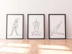 three black and white framed art prints on the wall in an empty room with hard wood flooring