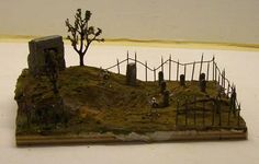 a miniature model of a cemetery with trees and fence