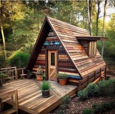 a small wooden cabin in the woods with stairs leading up to it's roof