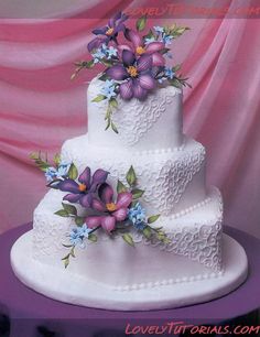 a three tiered cake with purple flowers on it