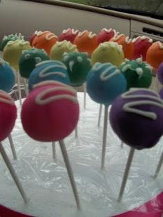 there are many cake pops that are on the table in front of the car window