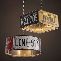 two light fixtures hanging from chains with license plates attached to the ceiling and below them