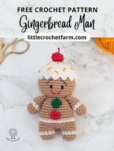 a crocheted gingerbread man is sitting on a table with scissors and yarn