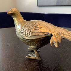 a golden bird figurine sitting on top of a table