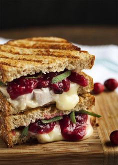 a grilled cheese and cranberry sandwich on a cutting board