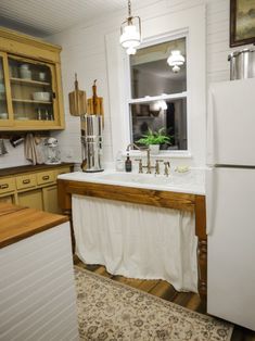 a white refrigerator freezer sitting inside of a kitchen next to a sink and window