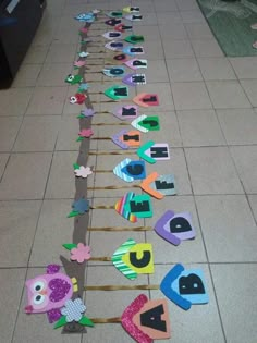 a long line of cut out letters sitting on top of a tiled floor