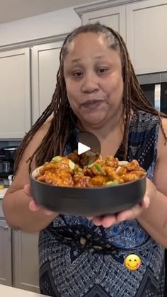 a woman holding a bowl of food in her hands