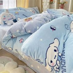 a child's bed with blue comforters and stuffed animals on the sheets,