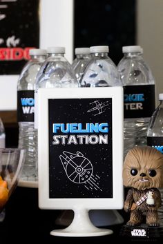 a star wars themed party with water bottles and action figures on the table next to it