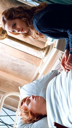 two women standing next to each other on top of a bed