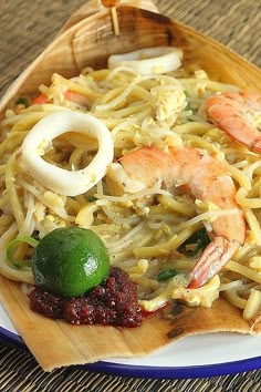 a plate with noodles and shrimp on it