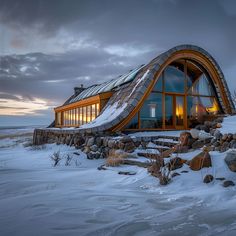 a house made out of rocks and wood in the snow with a sloped roof