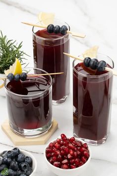 two glasses filled with blueberry juice and berries