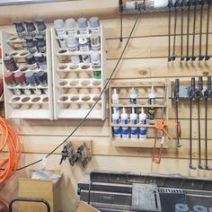 there are many tools hanging on the wall in this workshop, and one is holding an orange hose