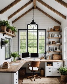 a home office with white walls and wooden beams, windows, desks and shelves