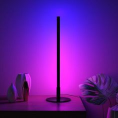 a purple light shines brightly on a table with two vases and a lamp