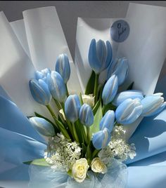 a bouquet of blue and white tulips with baby's breath