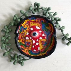 a colorful object is sitting next to some small green plants and beads on the table