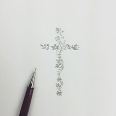 a pen sitting on top of a piece of paper with a cross drawn on it