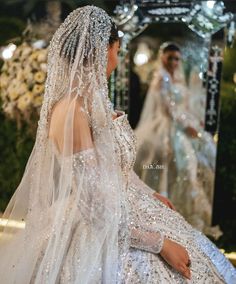 the back of a woman's wedding dress, with veil and headpieces