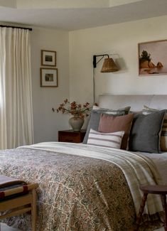 a bed sitting in a bedroom next to a window with curtains on the windowsill