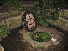 an outdoor fire pit in the middle of a garden with stone steps leading up to it