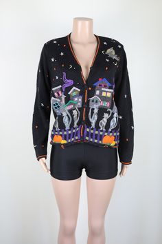 This amazing 90s Halloween themed Cardigan features a v neck collar, is long sleeved, and has fabric covered buttons up front.  The Cardigan also features cats, houses, stars, moons, pumpkins and best of all a beautiful flying witch the front of the knit.  On the back of the jumper is a single cat, a house, stars and a moon.  This jumper also has tiny pearly beads sewn into the jumper to add dimension and a bit of glam.  There a a few lose threads on this knit, however they are hardly noticeable Halloween Long Sleeve Cardigan, 90s Black Sweater For Fall, 90s Style Black Sweater For Fall, 90s Witch, Halloween Cardigan, Halloween Jumper, Goth 90s, Single Cat, 90s Halloween