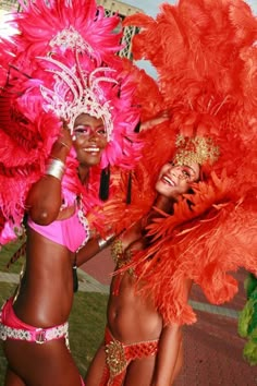 two women in red and pink costumes posing for the camera