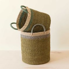 two baskets sitting on top of a table next to each other, one is green and the other is brown