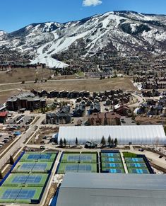 an aerial view of a city with mountains in the background and snow on the ground