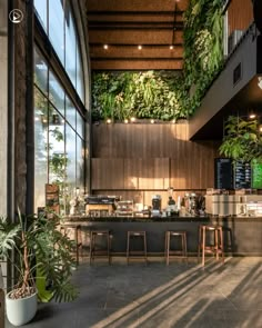 the inside of a restaurant with plants growing on the wall