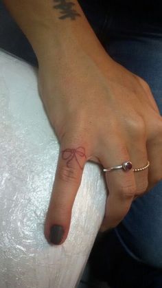 a woman's left hand with a tattoo on it