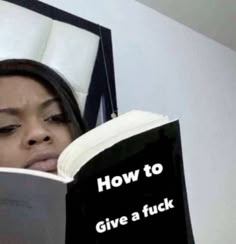 a woman reading a book that says how to give a f k