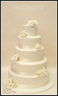 a three tiered wedding cake with white flowers