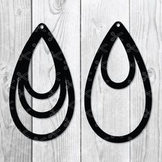 pair of black leather tear earrings on white wood planks with clipping for text