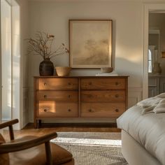 a bedroom with a bed, dresser and chair