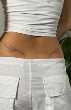 a woman's stomach with tattoos on her lower half and the bottom part of her pants