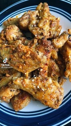 chicken wings with seasoning on a blue and white plate