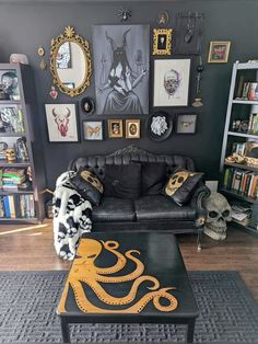 a living room filled with black furniture and pictures on the wall above it's coffee table