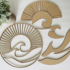 two circular cutouts with waves on them next to a potted plant