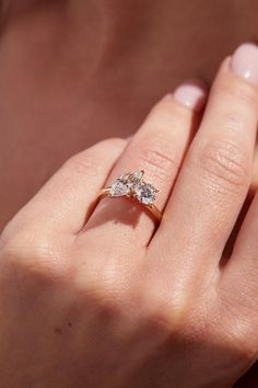 a woman's hand with a three stone ring on her left and right hand