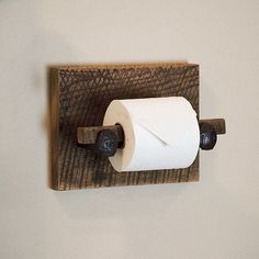 a toilet paper dispenser mounted to a wall with two rolls of toilet paper on it