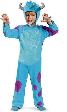 a little boy in a blue costume with purple spots on his face and hands up