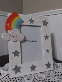 a white frame with silver stars and a rainbow