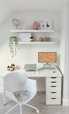 a white desk with a computer on top of it and shelves above the desk behind it