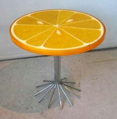 an orange slice sitting on top of a metal stand with four legs and two ends