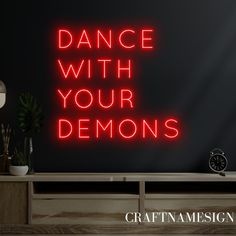 a red neon sign that reads dance with your demons on the side of a wall